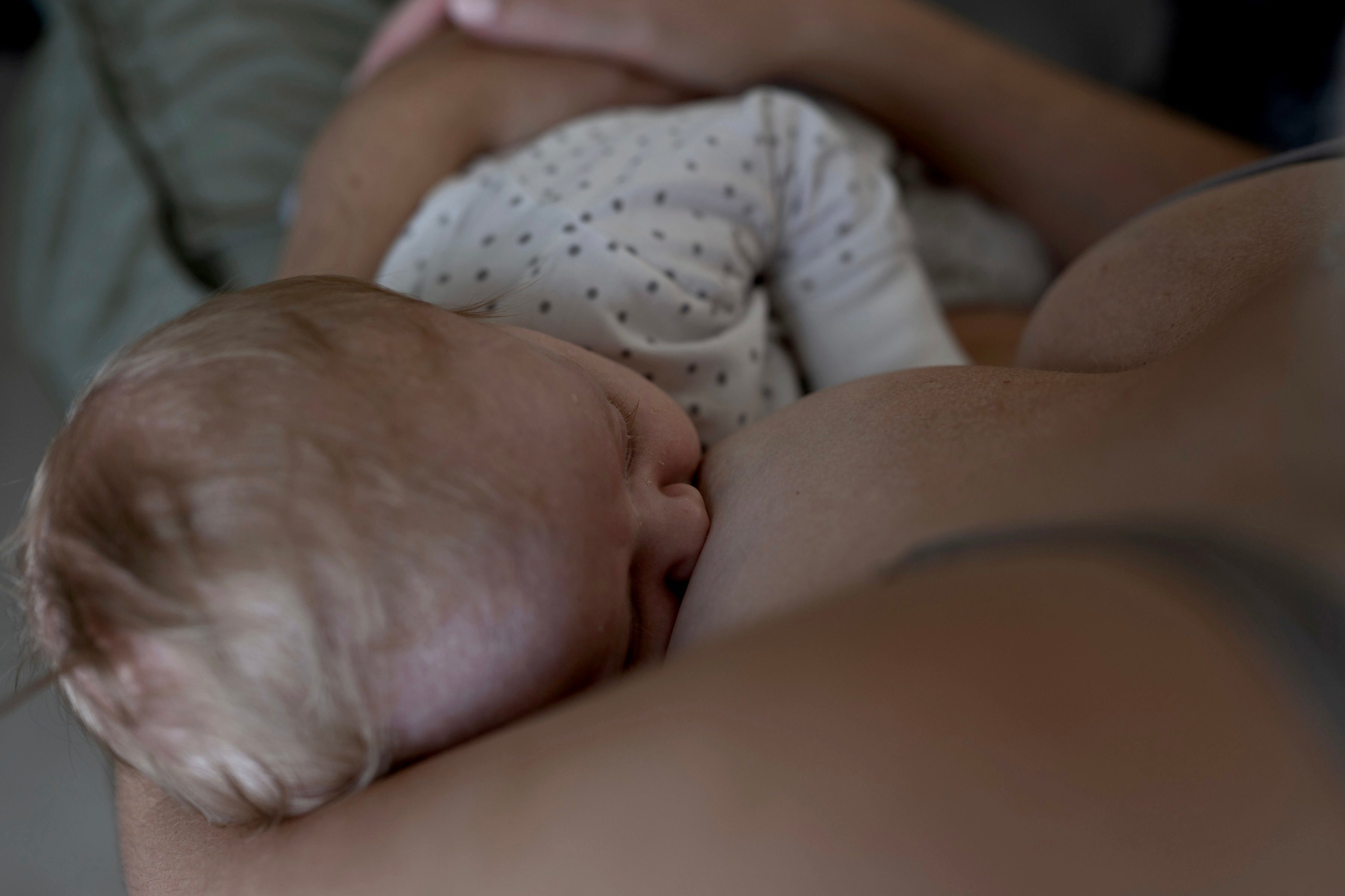 Förälder ammar sin bebis, kopplat till amningsaversion och blandade känslor under amning.